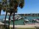 Scenic waterfront view with boats docked, palm trees, and residential buildings in the background on a sunny day at 7910 Sun Island S Dr # 404, South Pasadena, FL 33707