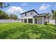 Large backyard featuring a lush green lawn, modern house, and a white fence at 816 W Orient St, Tampa, FL 33603