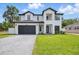 Modern two-story home featuring a manicured lawn and a black garage door at 816 W Orient St, Tampa, FL 33603