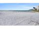 Expansive white sand beach with serene water and a bridge in the background at 830 S Gulfview Blvd # 102, Clearwater Beach, FL 33767