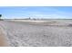 Beautiful white sand beach with calm waters and distant city skyline view, ideal for relaxation at 830 S Gulfview Blvd # 102, Clearwater Beach, FL 33767