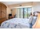 This cozy bedroom includes a queen bed, balcony with natural light, and traditional-style furnishings at 830 S Gulfview Blvd # 102, Clearwater Beach, FL 33767