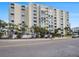 Multi-story condo building with balconies, palm trees, and street view, offering a tropical lifestyle at 830 S Gulfview Blvd # 102, Clearwater Beach, FL 33767