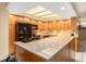 Bright kitchen with ample cabinet space, tile backsplash and flooring, granite countertops, and modern appliances at 830 S Gulfview Blvd # 102, Clearwater Beach, FL 33767