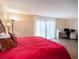 Cozy bedroom features a queen bed, sliding glass door with bright, natural light, and a comfortable desk area at 830 S Gulfview Blvd # 102, Clearwater Beach, FL 33767