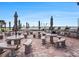 Outdoor patio area with multiple tables, seating, and built-in grills for gatherings at 830 S Gulfview Blvd # 102, Clearwater Beach, FL 33767