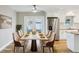 Staged dining room featuring bright light, stainless refrigerator, and white cabinetry at 8417 Bay Pointe Dr, Tampa, FL 33615