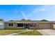 Charming single-story home with a well-maintained lawn and beautiful flowering tree at 8417 Bay Pointe Dr, Tampa, FL 33615