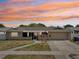 Charming single-story home with a well-maintained lawn and inviting curb appeal at sunset at 8417 Bay Pointe Dr, Tampa, FL 33615