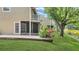 Backyard featuring a brick patio with a screened in lanai, lush greenery and pond views at 9050 Lake Place Ln, Tampa, FL 33634