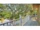 Balcony with white railing offering a view of a tranquil lake and lush trees at 9050 Lake Place Ln, Tampa, FL 33634
