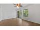 Bright bedroom featuring wood-look floors, a ceiling fan, and sliding glass doors to a patio at 9050 Lake Place Ln, Tampa, FL 33634