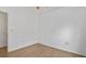 Simple bedroom with wood floors, white walls, and a doorway to another room at 9050 Lake Place Ln, Tampa, FL 33634