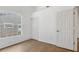 Bedroom with wood floors, white walls, a window with blinds, and an entrance to another room at 9050 Lake Place Ln, Tampa, FL 33634
