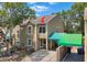 Exterior view of two-story tan home with covered parking at 9050 Lake Place Ln, Tampa, FL 33634