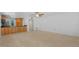 Open-concept living room featuring neutral tile floors and a partial view of the kitchen with wooden cabinets at 9050 Lake Place Ln, Tampa, FL 33634
