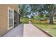 Brick patio overlooking a scenic pond and well-manicured lawn at 9050 Lake Place Ln, Tampa, FL 33634