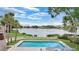 Community pool overlooking serene lake, complete with lounge area and shaded seating at 9050 Lake Place Ln, Tampa, FL 33634