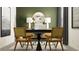 Stylish home office with wooden chairs, bold green wall, and decorative mirror creating a productive space at 9443 Raised Tulip Ln, Land O Lakes, FL 34637