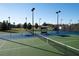 Community tennis court featuring a blue and green surface, benches, and perimeter lighting at 9487 Raised Tulip Ln, Land O Lakes, FL 34637