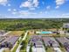 An overhead image showcasing a community pool and playground, set within the backdrop of a vast green preserve at 1009 Wynnmere Walk Ave, Ruskin, FL 33570