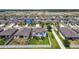 An aerial view reveals a gray two-story house with a lush, green backyard, in a Gathering-friendly neighborhood, surrounded by lakes at 1009 Wynnmere Walk Ave, Ruskin, FL 33570