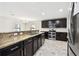 Kitchen boasts granite countertops, stainless steel appliances, dark cabinetry, and tile backsplash at 1009 Wynnmere Walk Ave, Ruskin, FL 33570