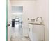 Functional laundry room featuring a stainless steel sink and sleek white cabinetry at 1009 Wynnmere Walk Ave, Ruskin, FL 33570
