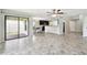 Open-concept living room features tile floors, sliding glass doors to the patio, and views of the kitchen at 1009 Wynnmere Walk Ave, Ruskin, FL 33570