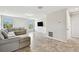Spacious living room with large sectional sofa, tile flooring and abundant natural light from two windows at 1009 Wynnmere Walk Ave, Ruskin, FL 33570