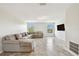 Bright living room showcasing a large sectional sofa and two windows bringing in natural light at 1009 Wynnmere Walk Ave, Ruskin, FL 33570