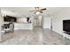 Open-concept living room showcasing tile floors, staircase access, and the eat-in kitchen with granite counters at 1009 Wynnmere Walk Ave, Ruskin, FL 33570