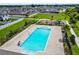 Aerial view of a sparkling community pool with a playground and green spaces in a well-maintained neighborhood at 1009 Wynnmere Walk Ave, Ruskin, FL 33570