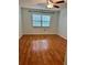 Neutral bedroom featuring wood-look floors, a ceiling fan, and a window offering outdoor views at 1020 85Th N Ave # 223, St Petersburg, FL 33702