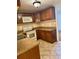 Well-maintained kitchen with brown cabinets, white appliances, and tile flooring at 1020 85Th N Ave # 223, St Petersburg, FL 33702