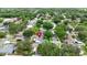 Aerial view of a tree-lined community with a serene pond and well-maintained homes at 10412 Tara Dr, Riverview, FL 33578