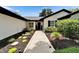Landscaped walkway leads to the home's entry, showcasing manicured bushes, stone accents and freshly laid mulch at 10412 Tara Dr, Riverview, FL 33578