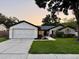 Charming home featuring a manicured lawn, two-car garage, and tasteful landscaping for enhanced curb appeal at 10412 Tara Dr, Riverview, FL 33578