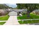 Beautiful single-story home featuring a two-car garage, mature landscaping and large shade tree at 10412 Tara Dr, Riverview, FL 33578