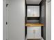 This laundry room features white cabinets, gold handles, and butcher block countertop on a charcoal accent wall at 10412 Tara Dr, Riverview, FL 33578