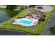 Aerial view of the community pool, with ample seating and overlooking a peaceful lake at 10412 Tara Dr, Riverview, FL 33578