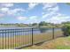 Scenic backyard with an iron fence offering an open view of the tranquil lake at 10424 Laguna Plains Dr, Riverview, FL 33578