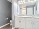Bathroom with dual sinks, white cabinets, granite countertop, toilet and shower at 10424 Laguna Plains Dr, Riverview, FL 33578