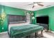 Bright bedroom shows decorative green walls, fan, and a large television at 10424 Laguna Plains Dr, Riverview, FL 33578