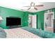 Green bedroom with painted stars, fan, doorway, television, and moons over doorway at 10424 Laguna Plains Dr, Riverview, FL 33578