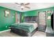 A bright bedroom features dark furniture, green walls, and a ceiling fan at 10424 Laguna Plains Dr, Riverview, FL 33578