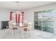 Bright dining area featuring a classic wooden table, elegant chandelier, and sliding doors to an outdoor patio at 10424 Laguna Plains Dr, Riverview, FL 33578