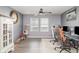 Bright home office featuring wood-look floors, a ceiling fan, and dual computer setup at 10424 Laguna Plains Dr, Riverview, FL 33578