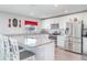 Modern kitchen with stainless steel appliances, granite countertops, a center island with bar stools, and white cabinets at 10424 Laguna Plains Dr, Riverview, FL 33578