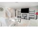 Well lit living room with sleek white furniture, modern decor, and a staircase leading to the second floor at 10424 Laguna Plains Dr, Riverview, FL 33578